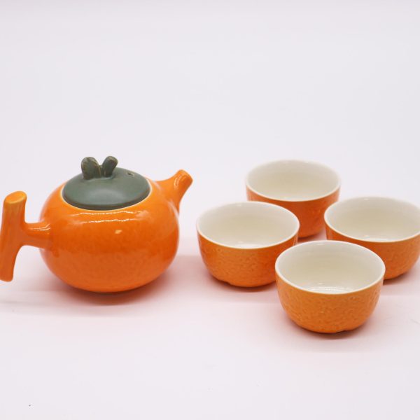 Service à thé théière et quatre tasses, mise en situation sur une table