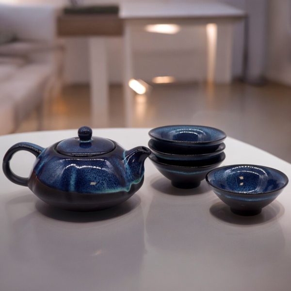 Service à thé théière et quatre tasses, mise en situation sur une table
