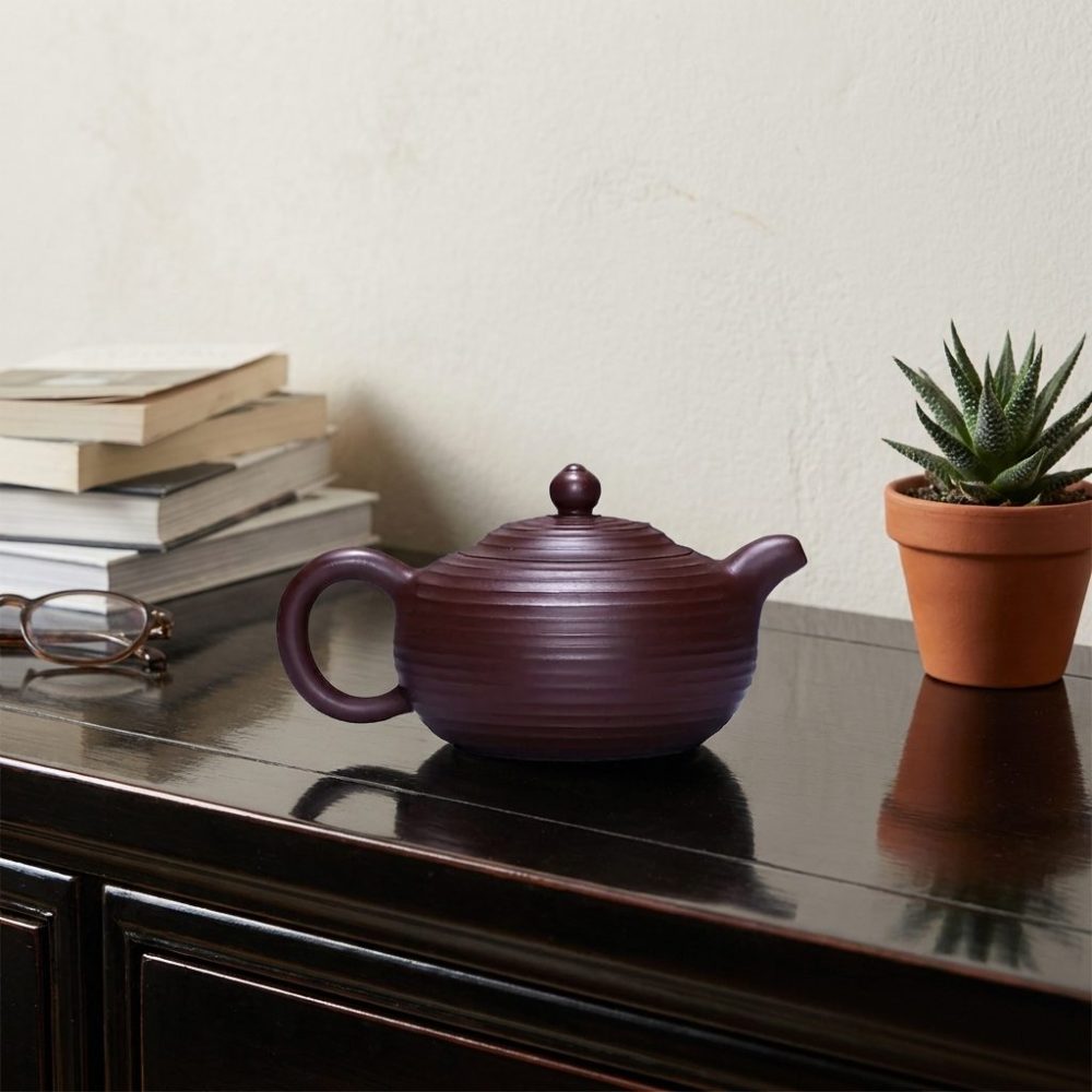 Théière de Yixing 250 ml — panse côtelée, filtre à boule, sur une console laquée