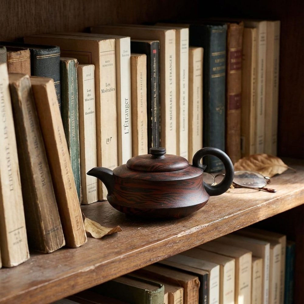 Théière de Yixing 280 ml — argile veinée, sur une étagère de bibliothèque