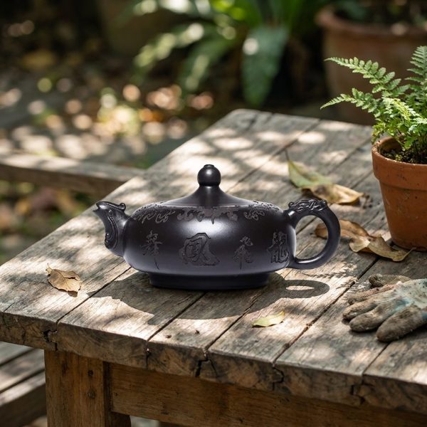 Théière de Yixing 200 ml — filtre à boule, argile brute, sur une table de jardin en teck