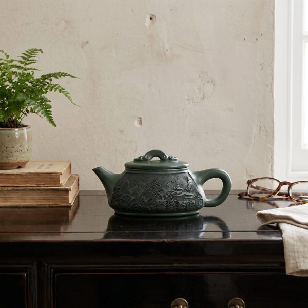 Théière de Yixing 340 ml — paysage gravé, argile verte, sur une console laquée