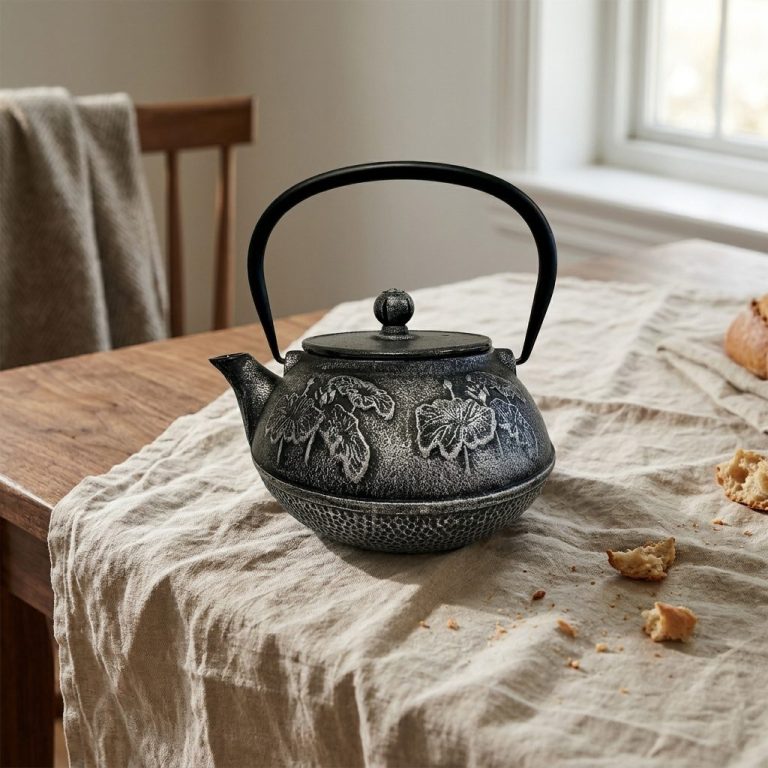 Théière en fonte 850 ml — noire, filtre inox, sur une table de salle à manger en noyer