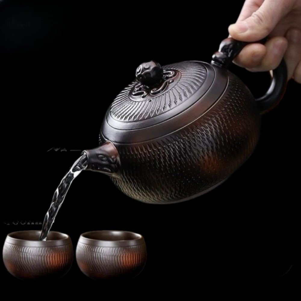 La théière versant dans deux tasses assorties de 100 ml