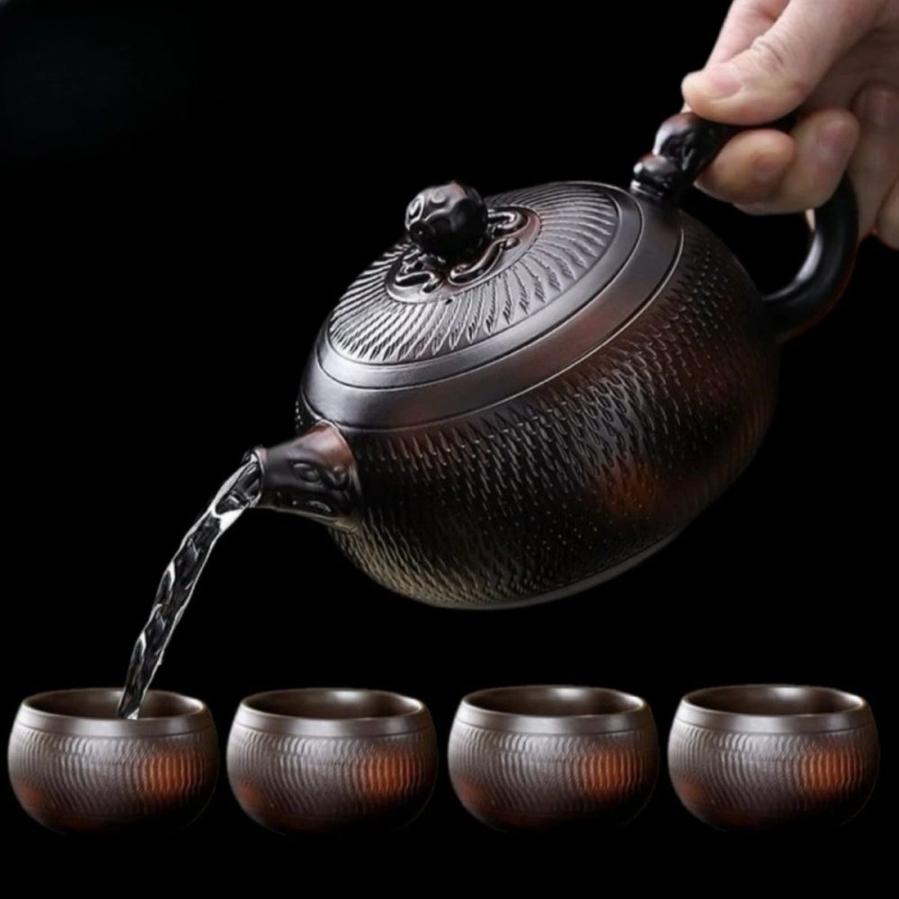 La théière versant dans quatre tasses assorties de 100 ml