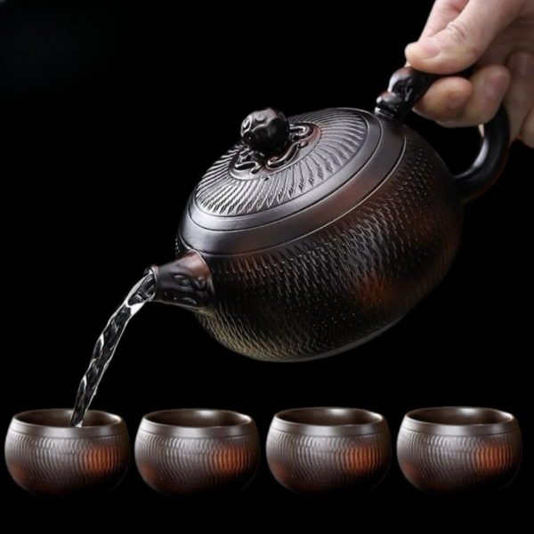 La théière versant dans quatre tasses assorties de 100 ml