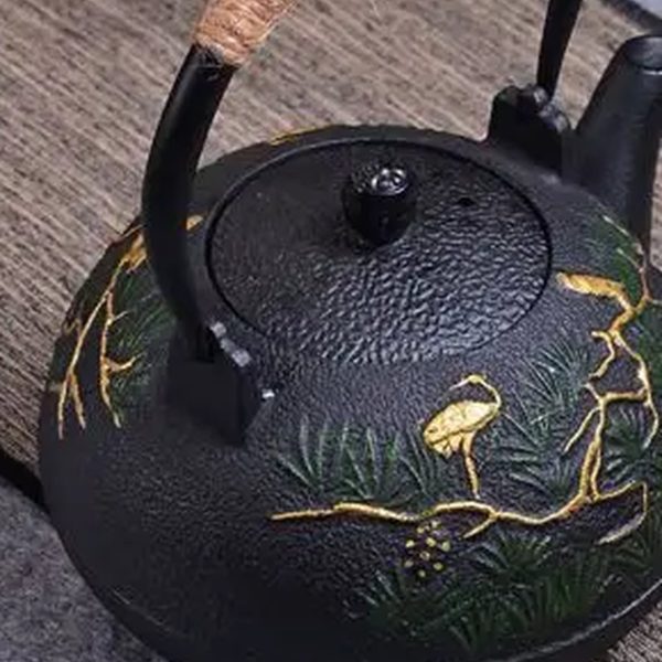 Théière en fonte 1,2 L, décor de pin incrusté d'or et de vert, vue de trois quarts