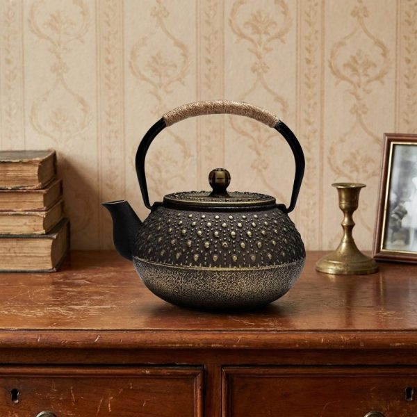Théière en fonte 900 ml à picots arare rehaussés d'or, sur un buffet ancien en merisier